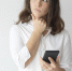 Pensive girl thinking over text message. Young Caucasian woman holding smartphone, leaning chin on hand and looking away. Reflecting and communication concept - Gatchinka.Ru